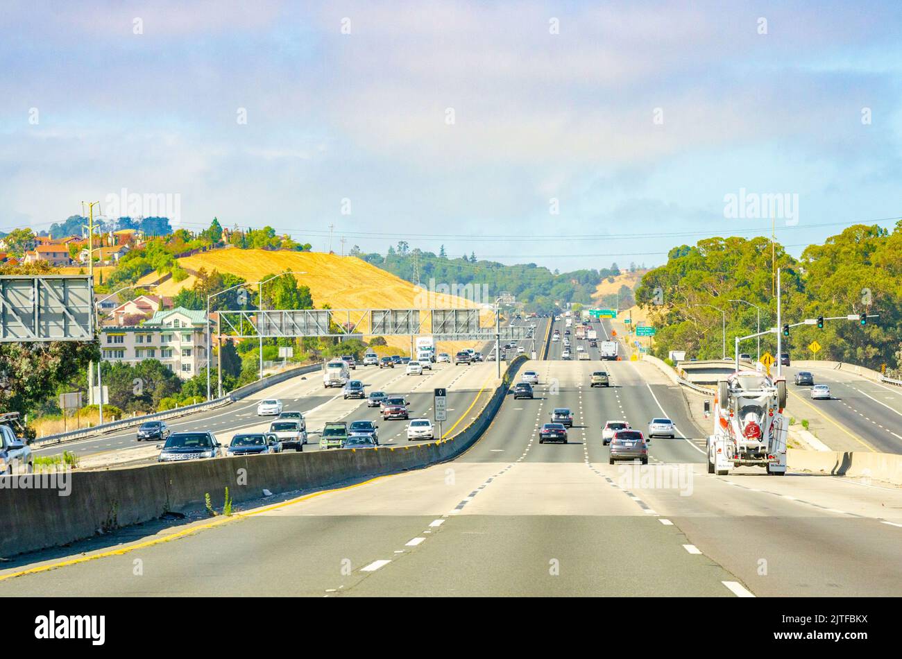 Guida lungo un'autostrada in California, USA con quattro corsie di traffico che viaggiano in entrambe le direzioni. Foto Stock