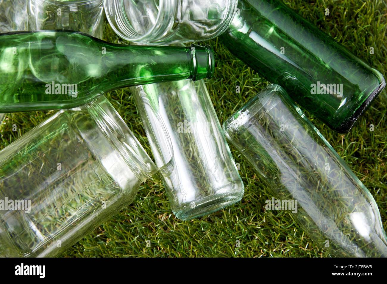 primo piano di bottiglie di vetro vuote e vasetti sull'erba Foto Stock