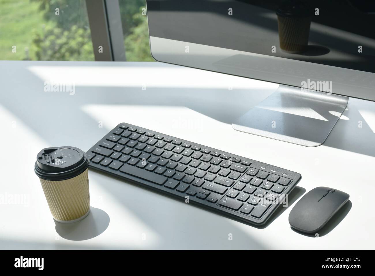 tastiera e mouse per computer con tazza di caffè calda sulla scrivania in ufficio Foto Stock