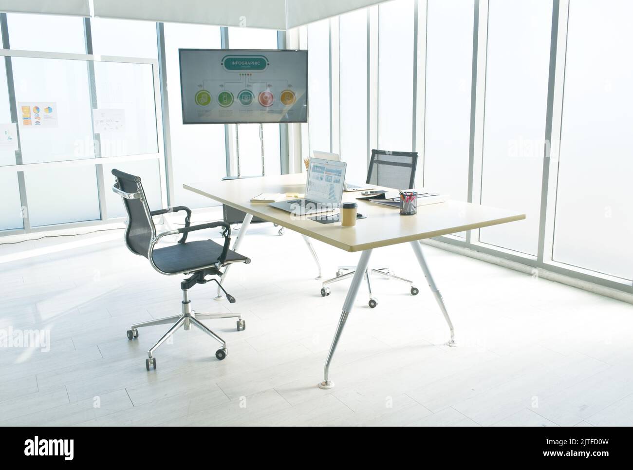 sala ufficio con servizi business per meeting e schermo televisivo con luce solare mattutina Foto Stock