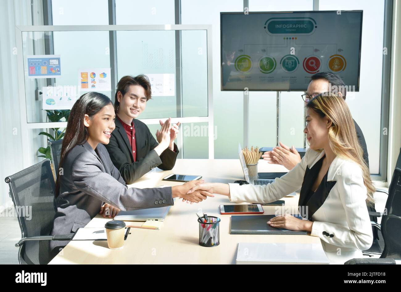 Le donne asiatiche di affari che scuotono la mano insieme dopo la riunione con successo e vincere l'affare nella stanza dell'ufficio Foto Stock