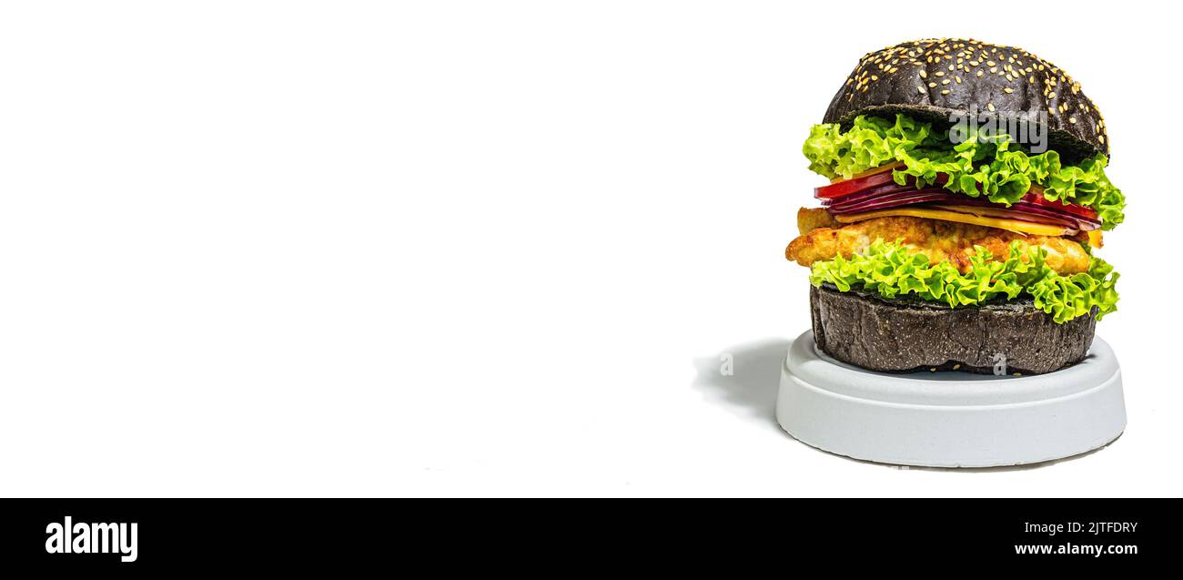 Hamburger di pesce fatto in casa con un panino nero. Ingredienti freschi, verdure mature, fast food. Moderno stand beton, luce dura alla moda, ombra scura, bann Foto Stock
