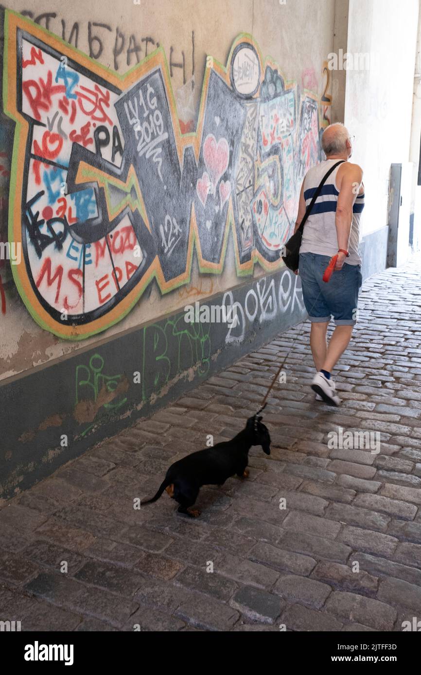 Uomo che cammina cane nella città di Liepaja, Lettonia Foto Stock