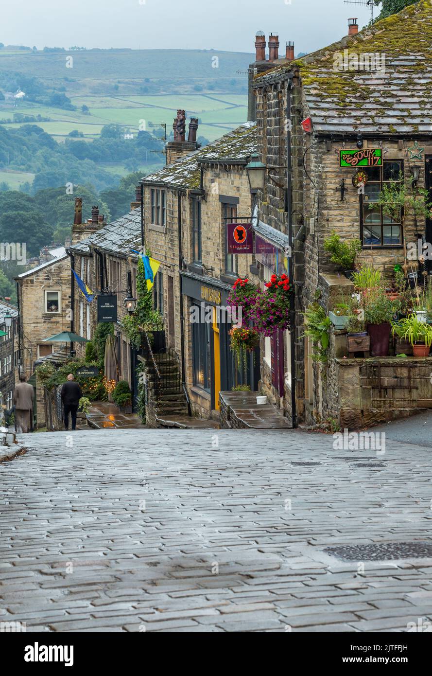 Cottages, negozi e caffè su Haworth Main Street nello Yorkshire. Haworht è famosa per essere la casa delle sorelle Bronte. Foto Stock