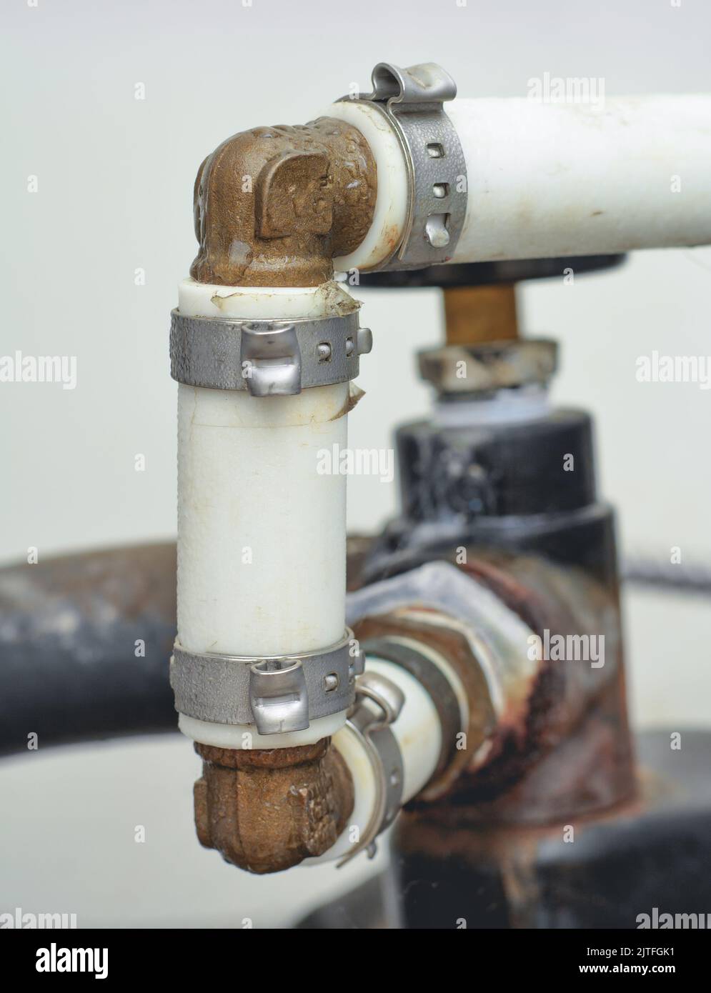 Tubazioni della pompa a pressione che includono tubi, fascette e gomiti di novanta gradi Foto Stock