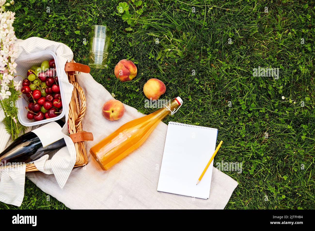 cibo, bevande e cestino da picnic sull'erba Foto Stock