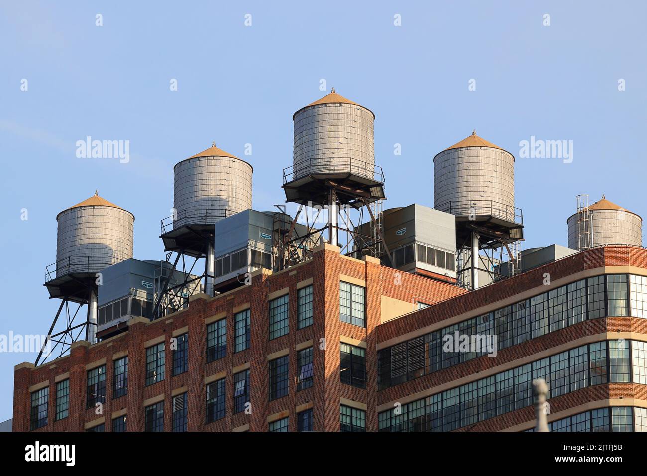 Serbatoi d'acqua in legno Rosenwach e unità di raffreddamento hvac sul tetto del magazzino Starrett-Lehigh trasformato in ufficio a New York. Foto Stock