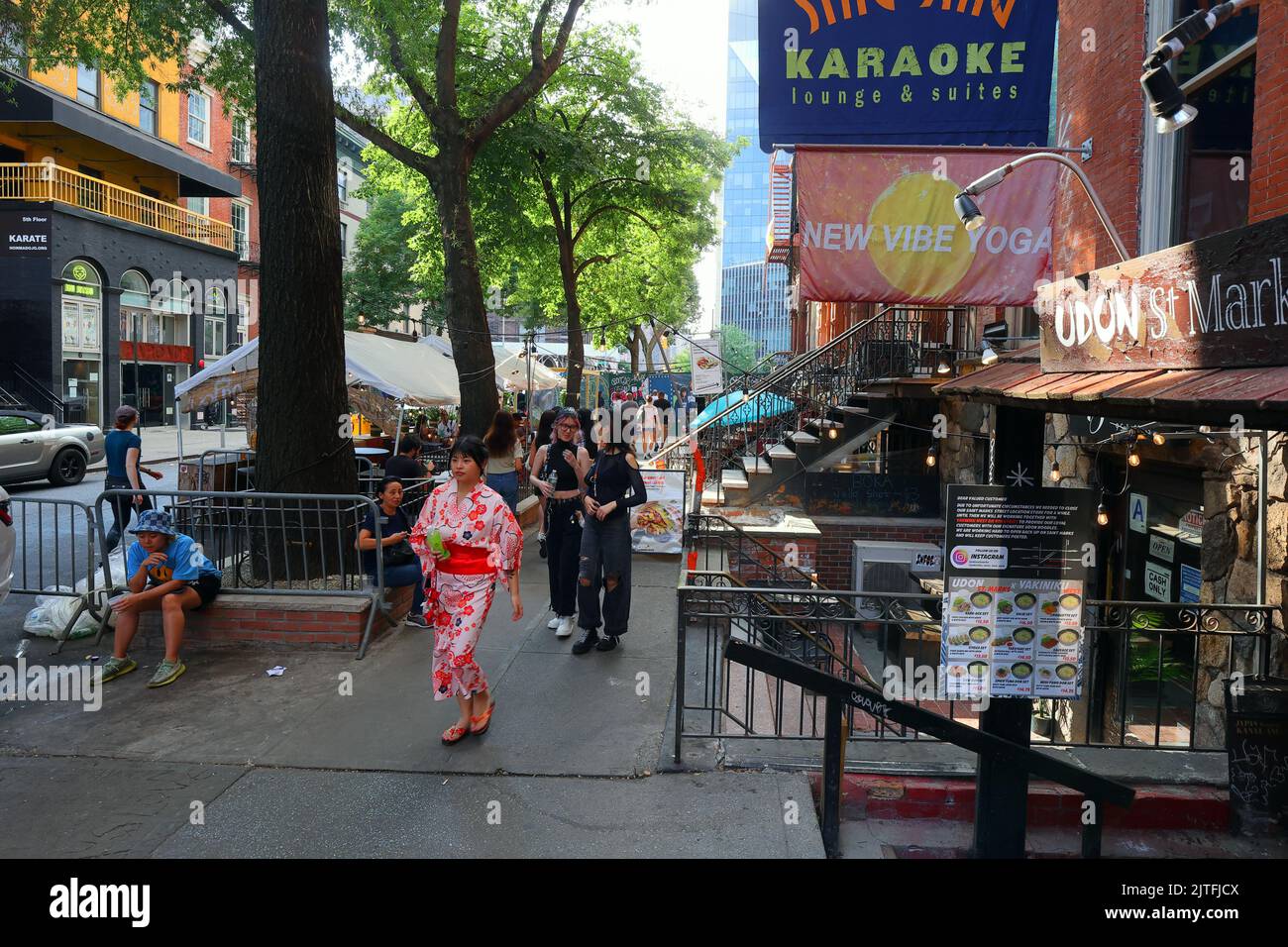 Asian Americani camminando lungo St. Marks Pl nel quartiere 'Little Tokyo' East Village di Manhattan, New York City. Foto Stock