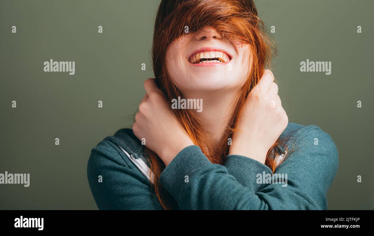 donna che esprime gioia toothy sorriso capelli disordine Foto Stock