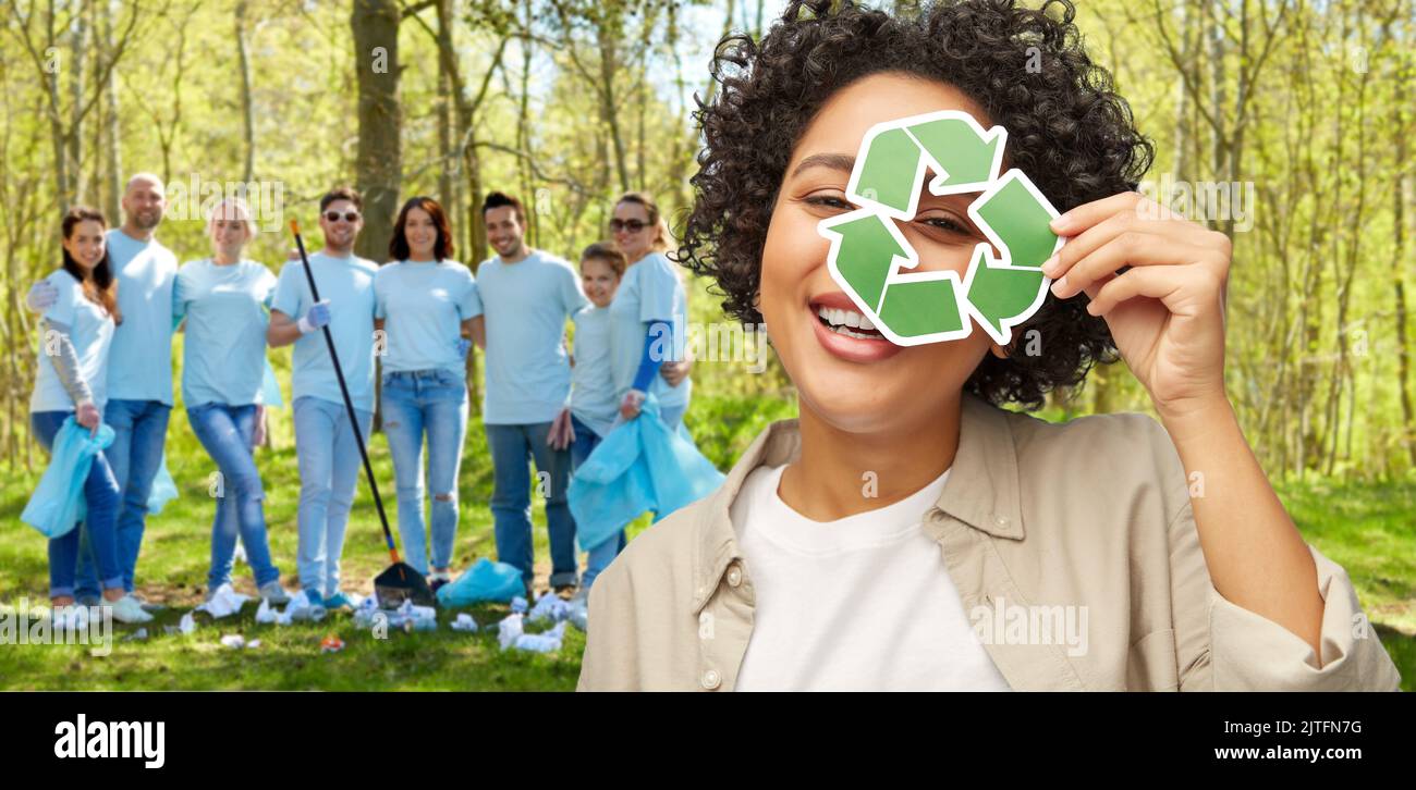 donna felice guardando attraverso il segno verde di riciclaggio Foto Stock