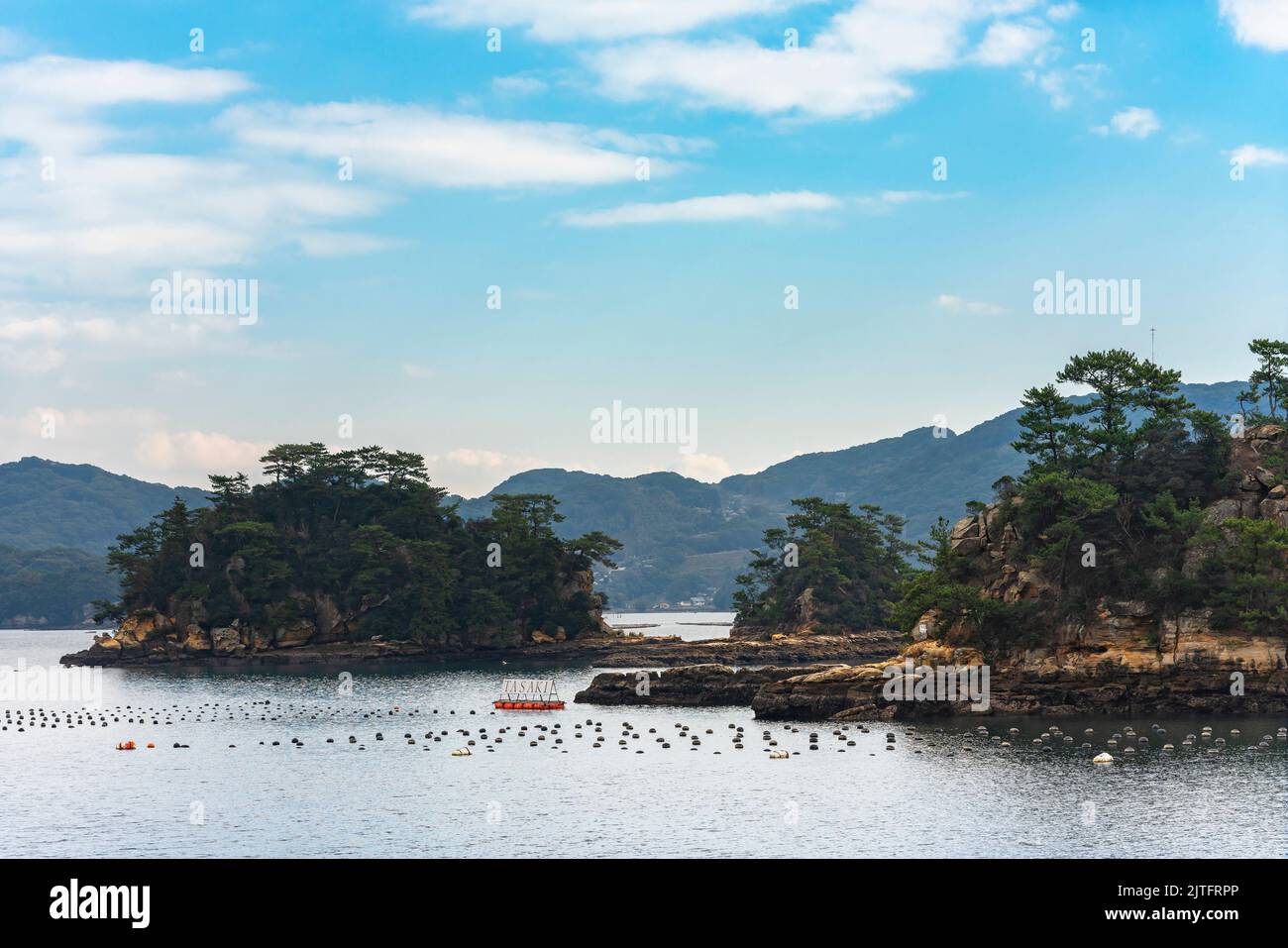 kyushu, giappone - dicembre 09 2021: Isolette nelle isole di Kujukushima di fronte alle palline galleggianti di una zattera utilizzata per la cultura delle ostriche perlacee della WO Foto Stock