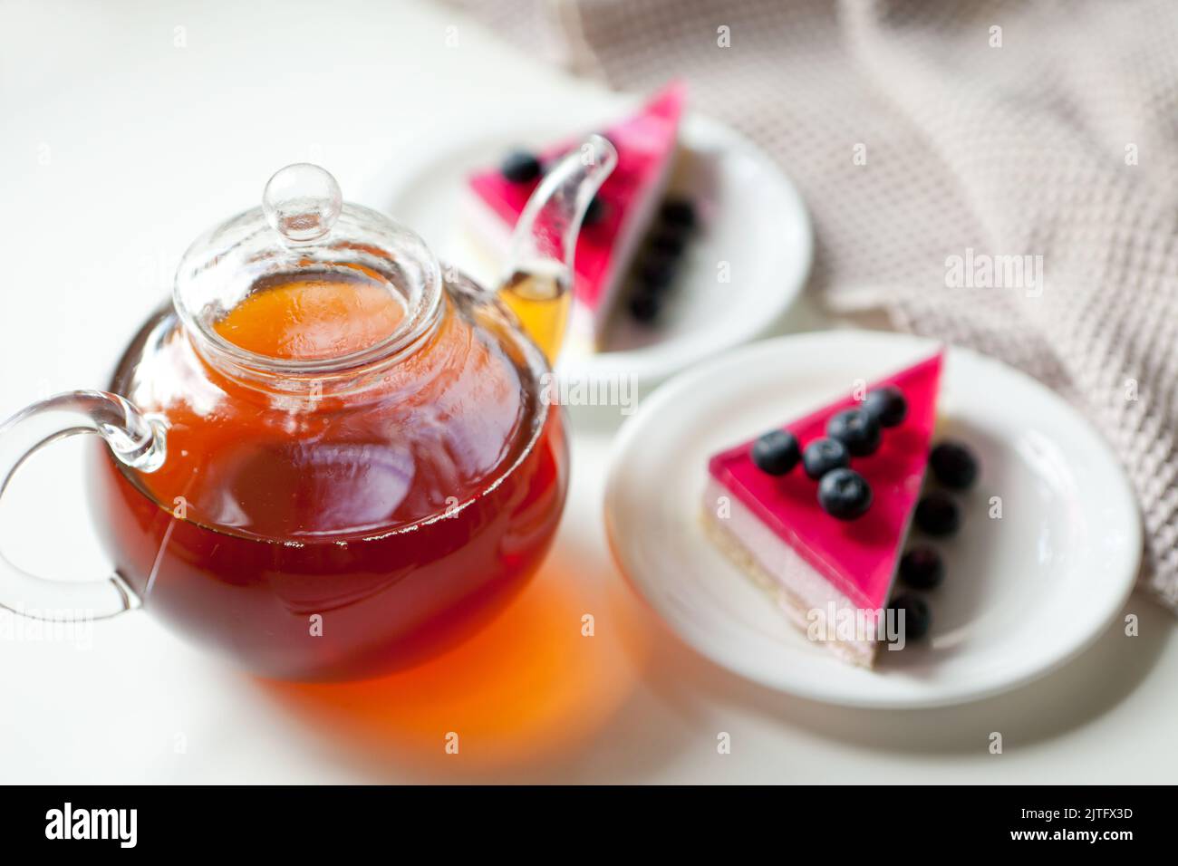 teiera di vetro con bevanda calda e torte con frutti di bosco. bevanda per dessert dolce Foto Stock