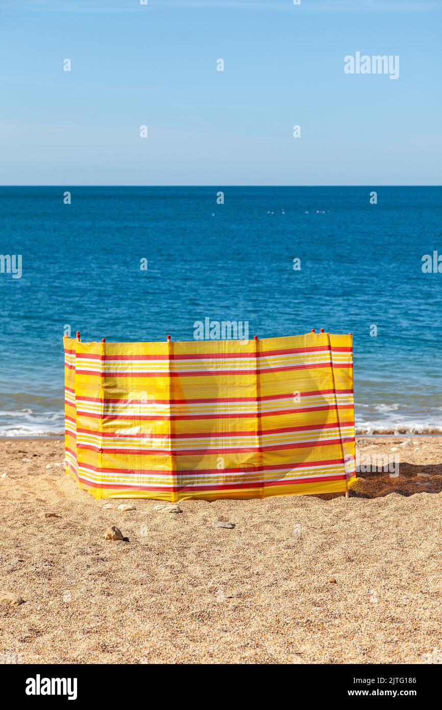 Solitario frangivento su una spiaggia di ciottoli Foto Stock