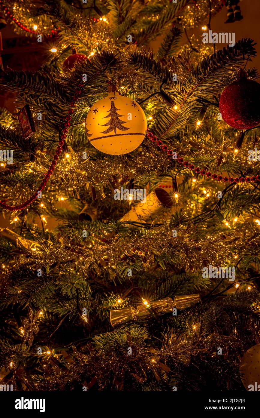 Oro e rosso albero di Natale decorazioni tra luci e baubles Foto Stock