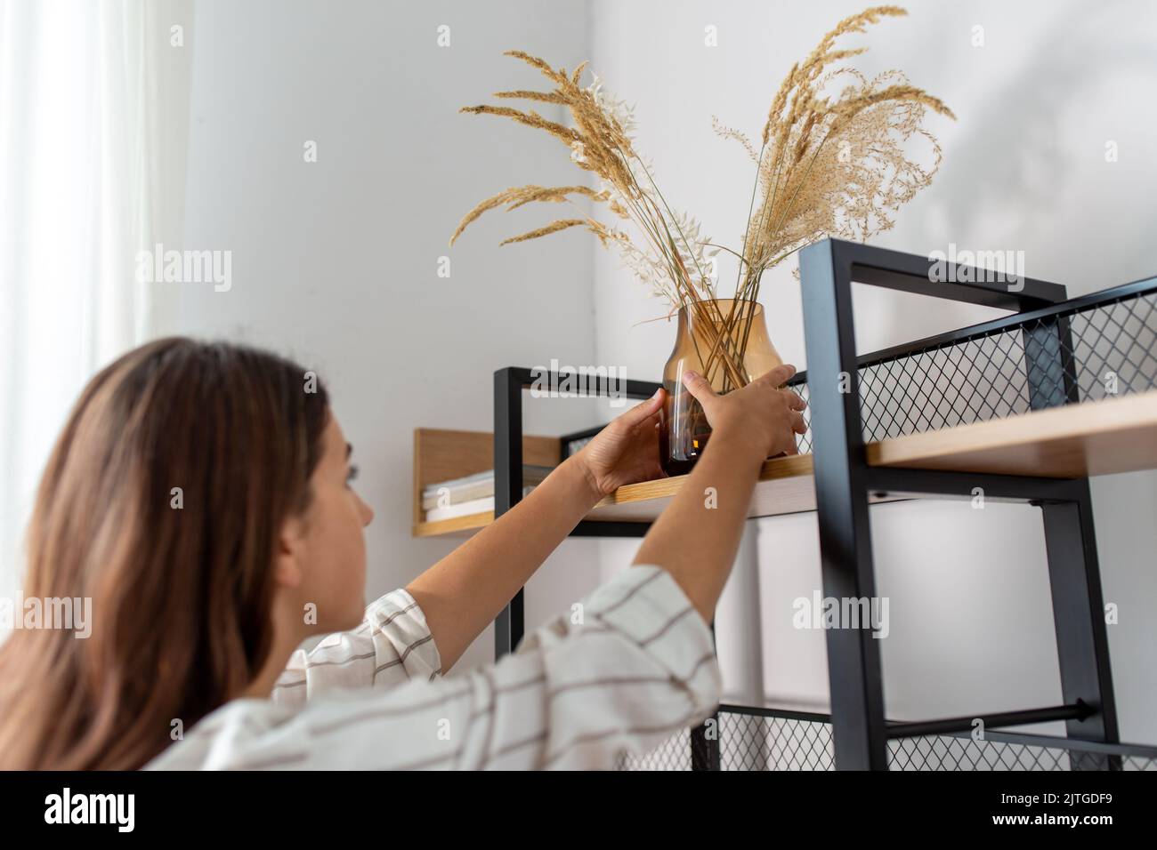 donna decorazione casa con fiori secchi in vaso Foto Stock