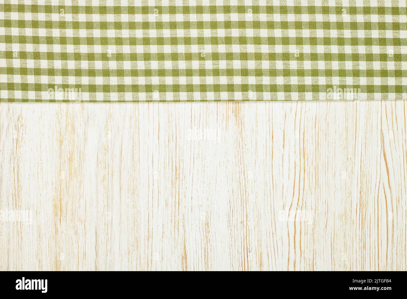 Tovaglia verde a scacchi su fondo tavolo in legno bianco. Vista dall'alto, disposizione piatta con spazio di copia, striscione Foto Stock