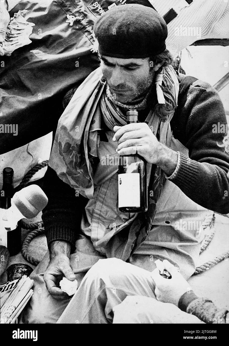 AJAXNETPHOTO. 12TH APRILE 1974. PORTSMOUTH, INGHILTERRA. - MEDIA INTERVISTA - FRANCESE CO-SKIPPER DI WHITBREAD ROUND THE WORLD GARA ENTRY 33 ESPORTAZIONE JEAN-PIERRE MILLET FOTO GODENDO DI PANE E VINO DURANTE L'INTERVISTA CON I MEDIA FRANCESI IN ARRIVO SICURO A HMS VERNON AL TERMINE DELL'ULTIMA TAPPA DI GARA. IL CO-SKIPPER DI MILLET DOMINIQUE GUILLET È STATO PERSO A BORDO DELLO YACHT IL 23RD NOVEMBRE 1973 DOPO CHE LO YACHT È STATO ROVESCIATO DA UN'ONDA CANAGLIA IN FORTIES N.E. RUGGENTE OF KERGUELEN ISLANDS.PHOTO:JONATHAN EASTLAND/AJAX RIF:340 220105 30 Foto Stock