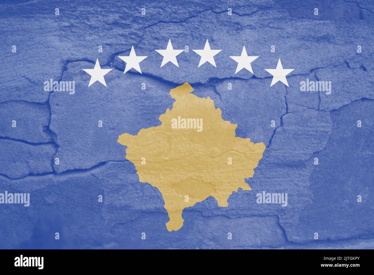 Sfocare correttamente la bandiera della Repubblica del Kosovo, i colori ufficiali e le proporzioni. Bandiera nazionale del Kosovo. Sfondo muro di pietra. Incrinatura. Democrazia. Fuori fuoco. Foto Stock