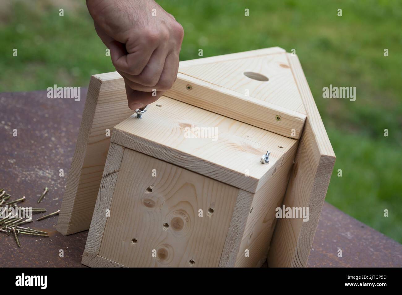 serie di scatole nest, passo 9/13: il deflettore anteriore, il deflettore di pulizia viene inserito e serrato con viti ad alette Foto Stock