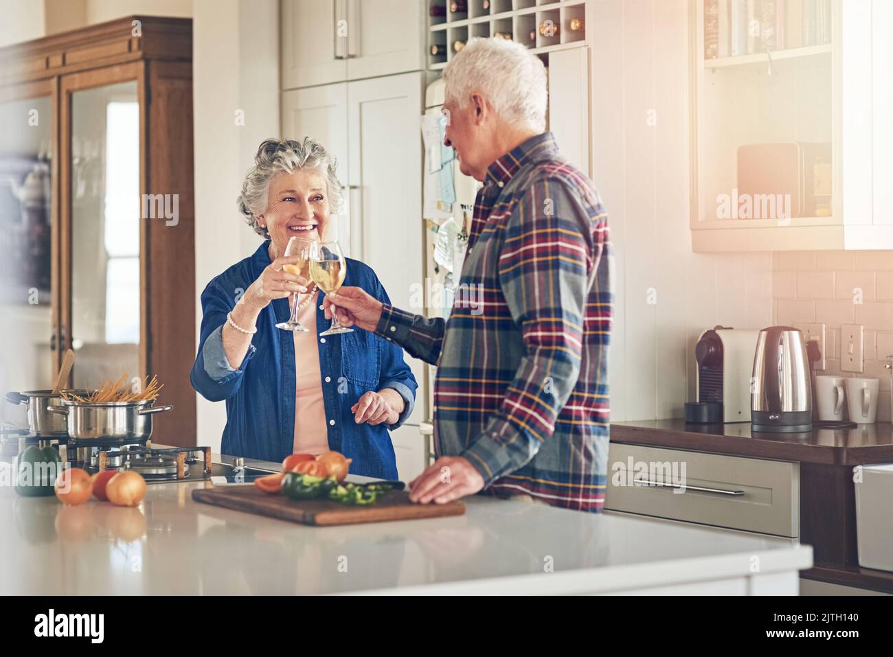 La vita è solo migliore insieme. Una coppia sorridente senior che cucinano insieme nella loro cucina a casa. Foto Stock