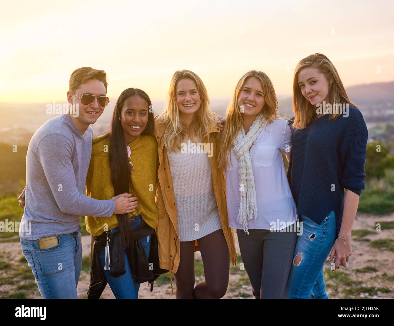 Gli amici sono la famiglia che scegliamo. Ritratto di un gruppo di amici che si posano insieme in piedi fuori. Foto Stock