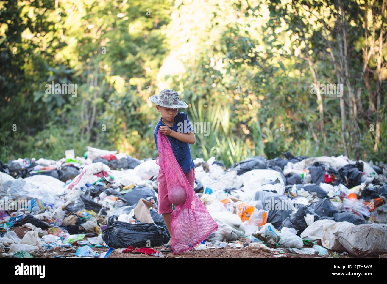 Concetto di povertà, i bambini poveri raccolgono spazzatura per la vendita a causa della povertà, riciclaggio spazzatura, lavoro minorile, Giornata mondiale dell'ambiente, Foto Stock