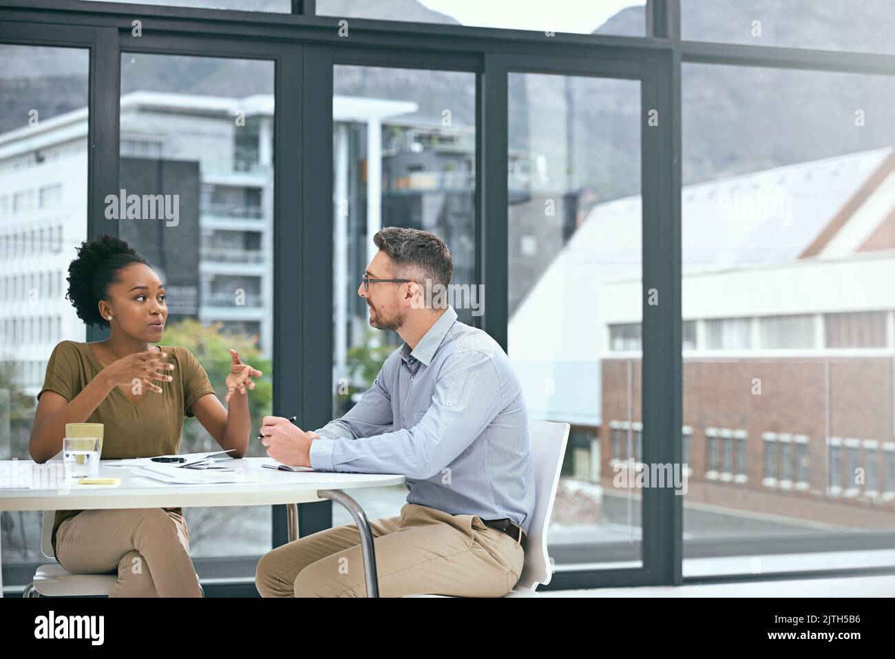 Ripercorrendo i dettagli, due colleghi che hanno una riunione in un ufficio. Foto Stock