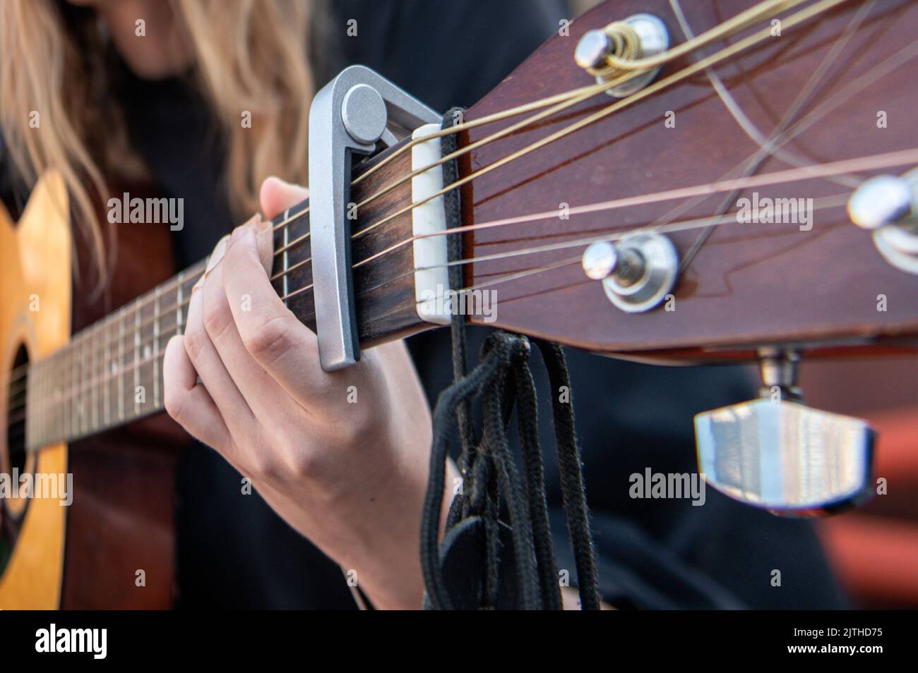 Primo piano di una donna che suona la chitarra. Mano di donna che suona la  chitarra per strada. Apprendimento di musica Foto stock - Alamy