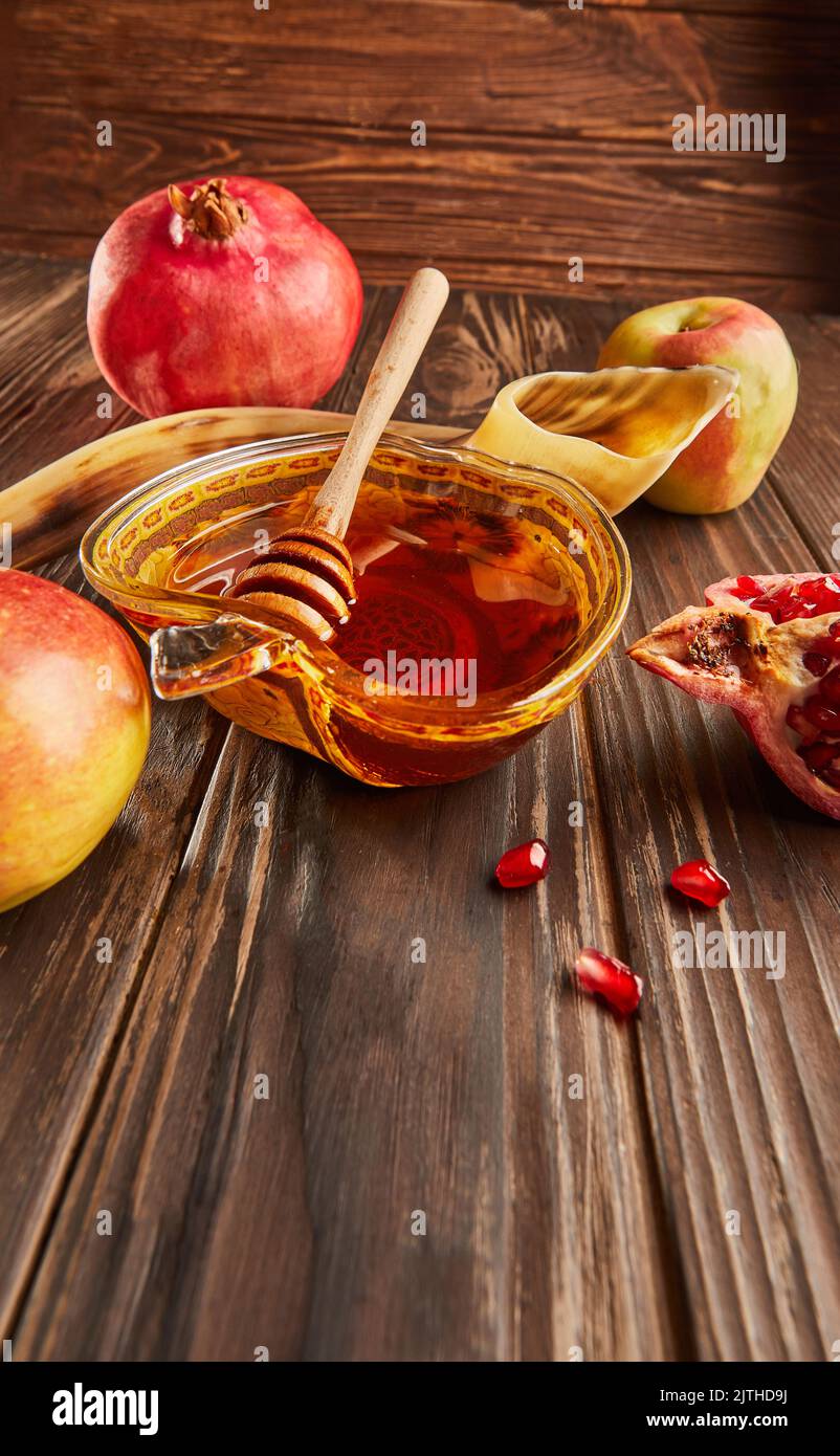 Rosh hashanah - concetto ebraico di vacanza di nuovo anno. Ciotola a forma di mela con miele, mele, melograni, shofar su fondo di legno d'annata Foto Stock
