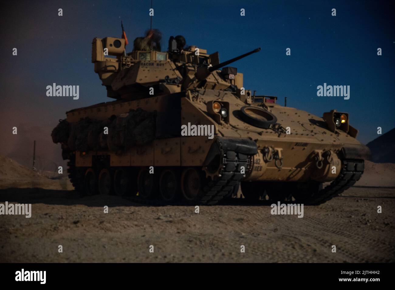 Un veicolo da combattimento Bradley assegnato al 1st Combined Arms Battalion, 63rd Armor Regiment, 2nd Armored Brigade Combat Team, 1st Infantry Division attende di assalire una città fittizia durante gli allenamenti presso il National Training Center di Fort Irwin, California, 11 agosto 2022. Un mix di unità blindate e di fanteria ha violato le difese della città come parte dell'esercizio di allenamento. (STATI UNITI Esercito foto di PFC. Kenneth Barnet) Foto Stock