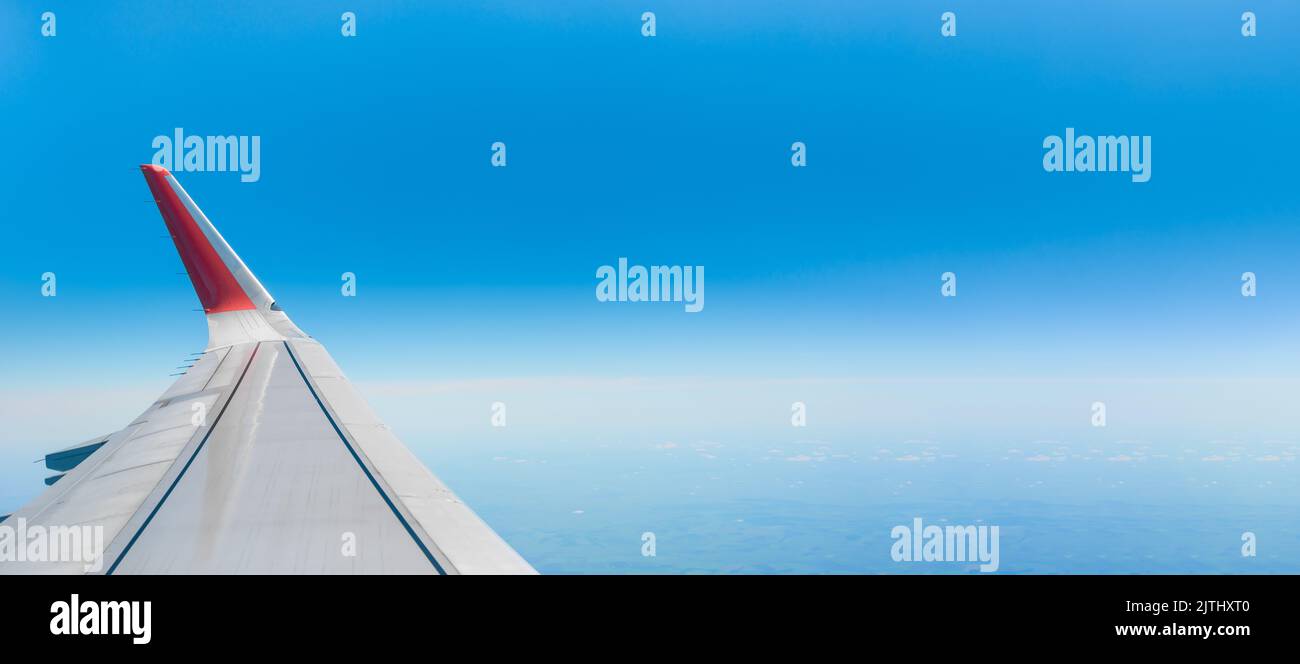 Ali di aeroplano e bellissimo paesaggio preso dall'aereo interno. Viaggi, turismo, vacanze, week-end, concetti di compagnia aerea. Aereo ala su cielo con slightl Foto Stock