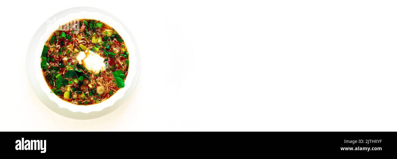 Piatto estivo tradizionale - borscht freddo con uova di patate, erbe aromatiche, ravanello, cetriolo, barbabietola, panna acida. Un piatto di cucina Ucraina, Polacca e russa. Sfondo isolato bianco. Foto Stock