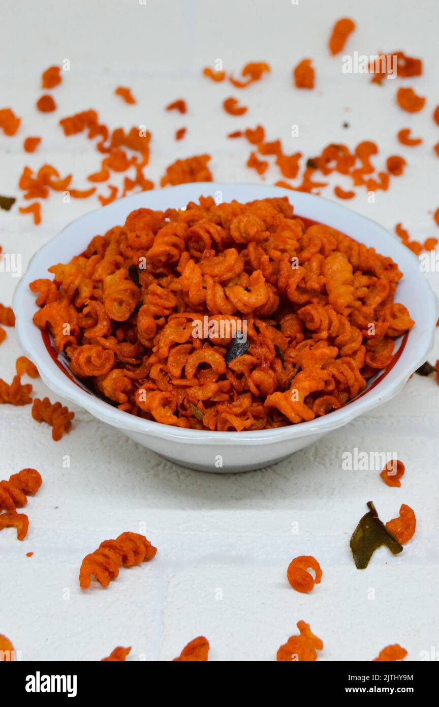 Maccheroni piccanti e saporiti in una ciotola su fondo bianco. I maccheroni secchi hanno una sensazione diversa quando vengono consumati come snack. Foto Stock