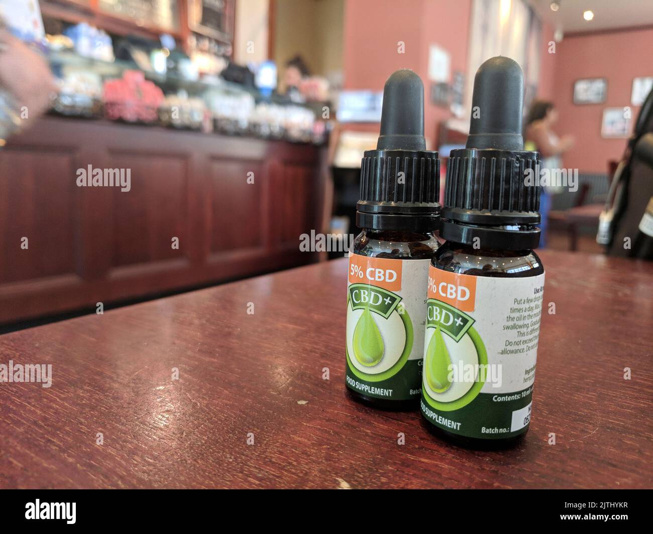 Due bottiglie di olio CBD su un tavolo in un bar, utilizzate per controllare il dolore. Foto Stock