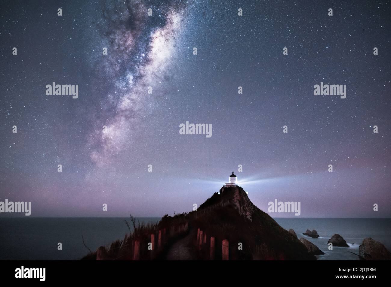 La Via Lattea che sorge sopra il faro di Nugget Point, Southland. Foto Stock