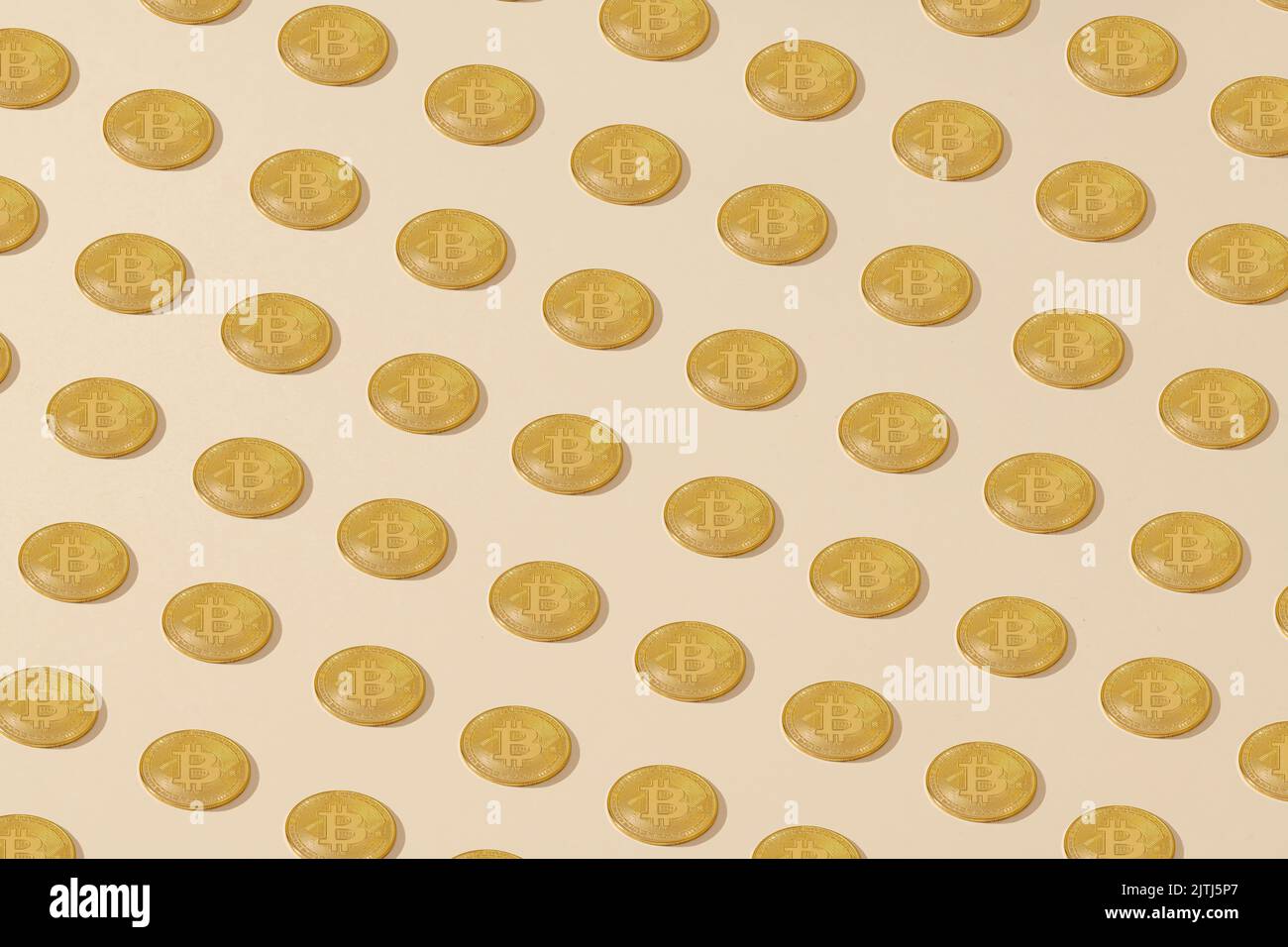 Bitcoin. Monete di bitcoin giallo dorato posizionate isometricamente su uno sfondo crema Foto Stock