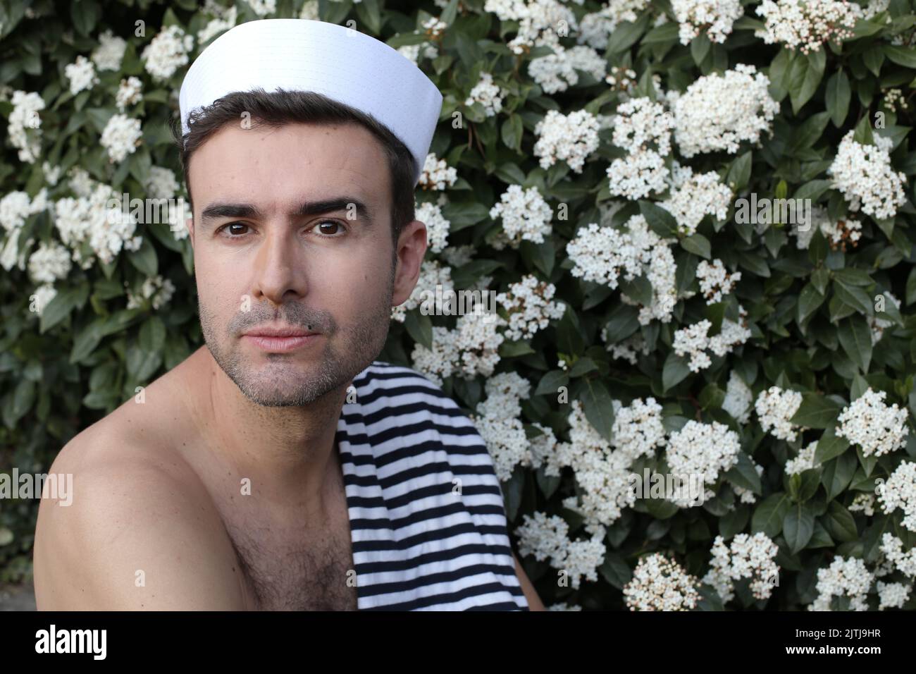 Splendido marinaio in posa in romantico sfondo floreale Foto Stock