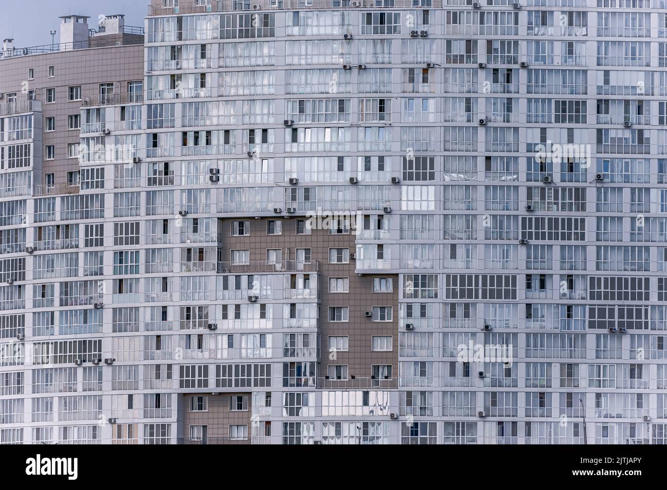 Finestre e balconi dell'edificio residenziale. Vista astratta su un complesso residenziale di appartamenti Foto Stock