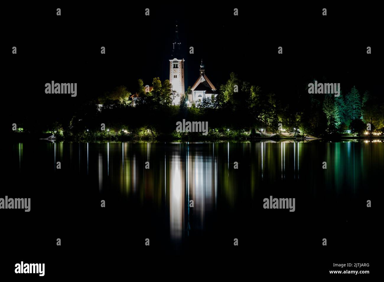 Chiesa della madre di dio sul lago di Bled, Slovenija nella notte. La luce si rifelce sull'acqua del lago di Bled. Foto Stock