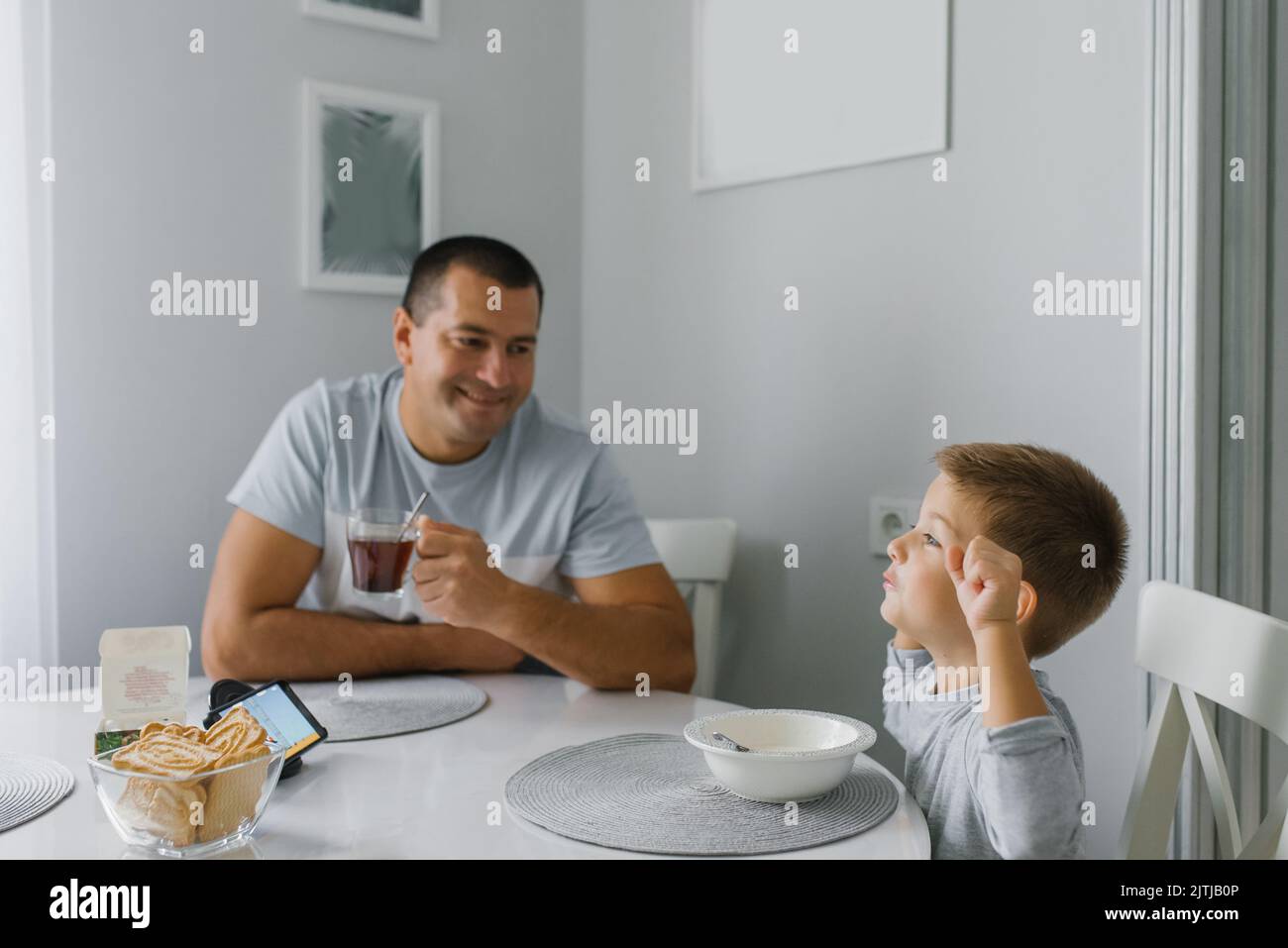 Buon papà e suo figlio fanno colazione in cucina Foto Stock