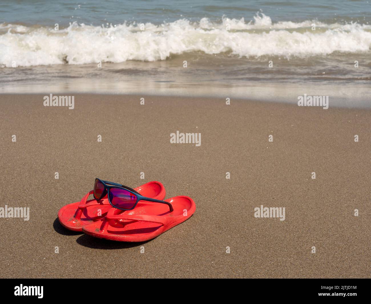 Flip flop simbolico sulla spiaggia Foto Stock