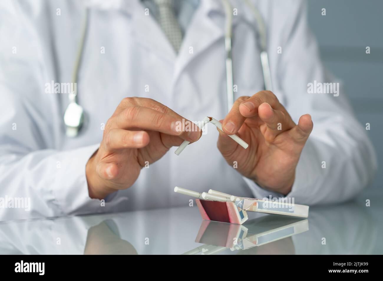 Il medico in uniforme rompe la sigaretta. Concetto di smettere di fumare Foto Stock