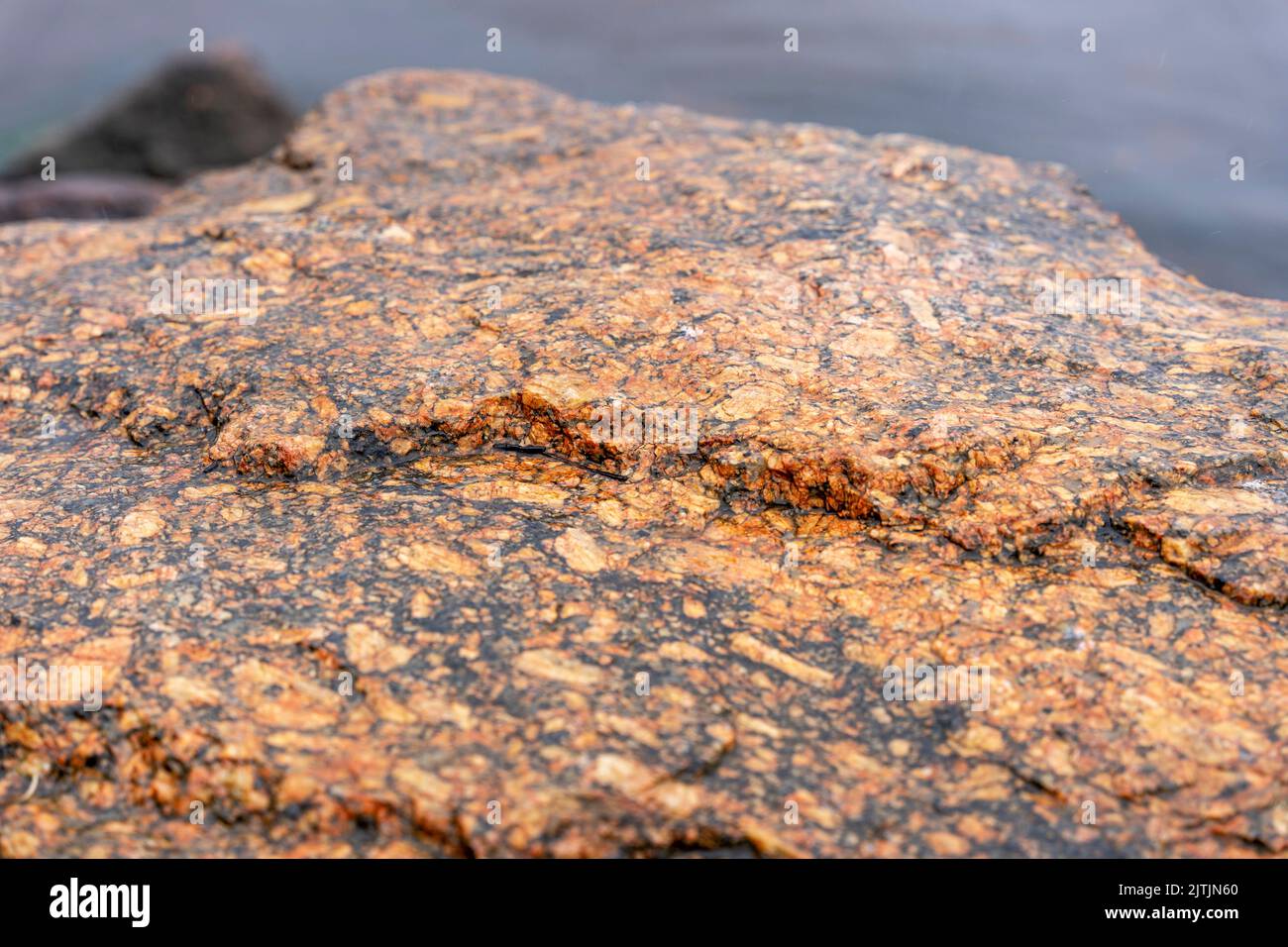 superficie testurizzata di un'enorme pietra naturale marrone-rossa Foto Stock