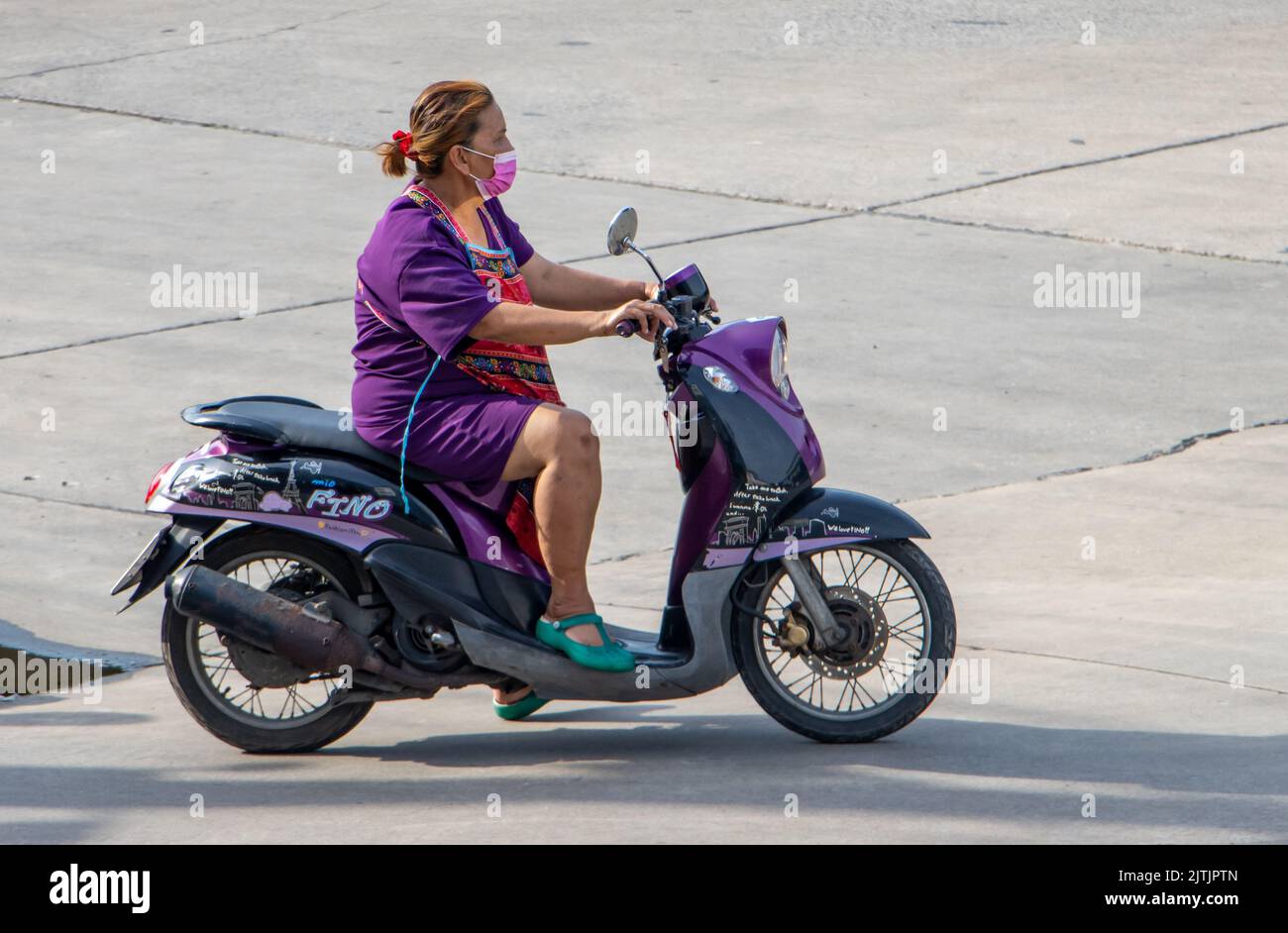SAMUT PRAKAN, THAILANDIA, 29 2022 MAGGIO, Una donna con maschera facciale cavalca una moto Foto Stock