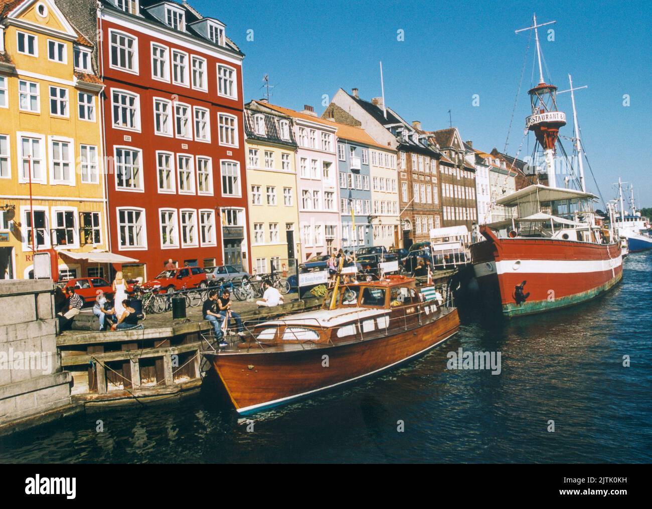 COPENHAGEN Nyhavn con i suoi piccoli caffè e bar lungo l'area del porto Foto Stock