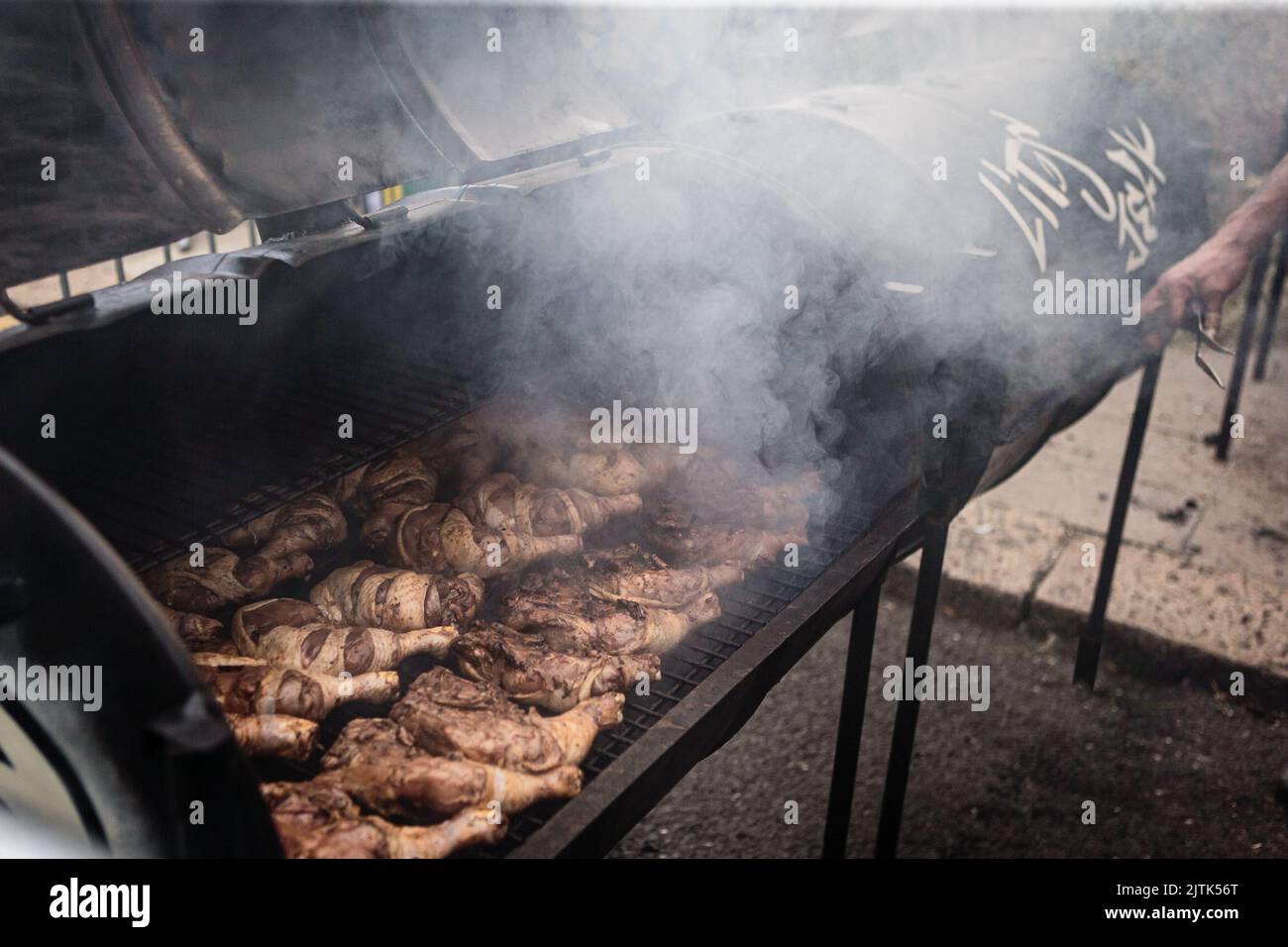 Al Notting Hill Carnival, cuocere a vapore con pollo alla griglia caraibico a jerk. Foto Stock