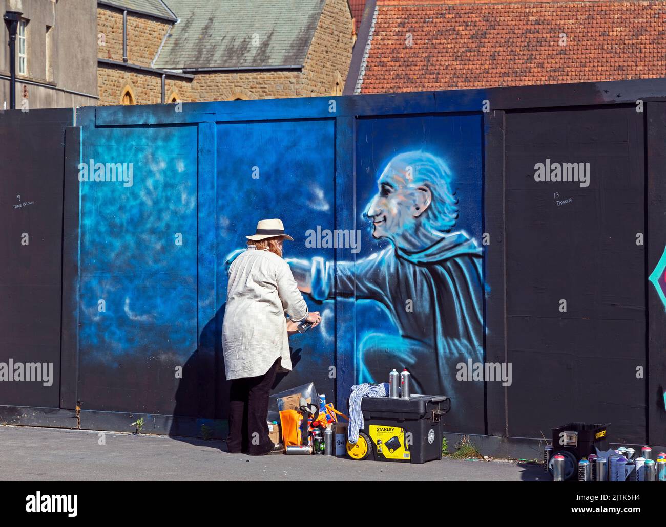 Weston-super-Mare, Regno Unito, 27 agosto 2022, artista al lavoro in una marmellata di pittura nel sito dell’ex stazione di polizia della città. La stazione di polizia è stata demolita nel 2019 e il sito è in attesa di essere risviluppato. Foto Stock