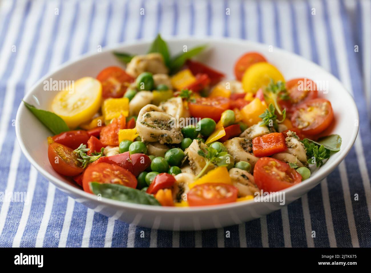 Tortellini vegani con verdure miste e pesto superiore alle carote Foto Stock