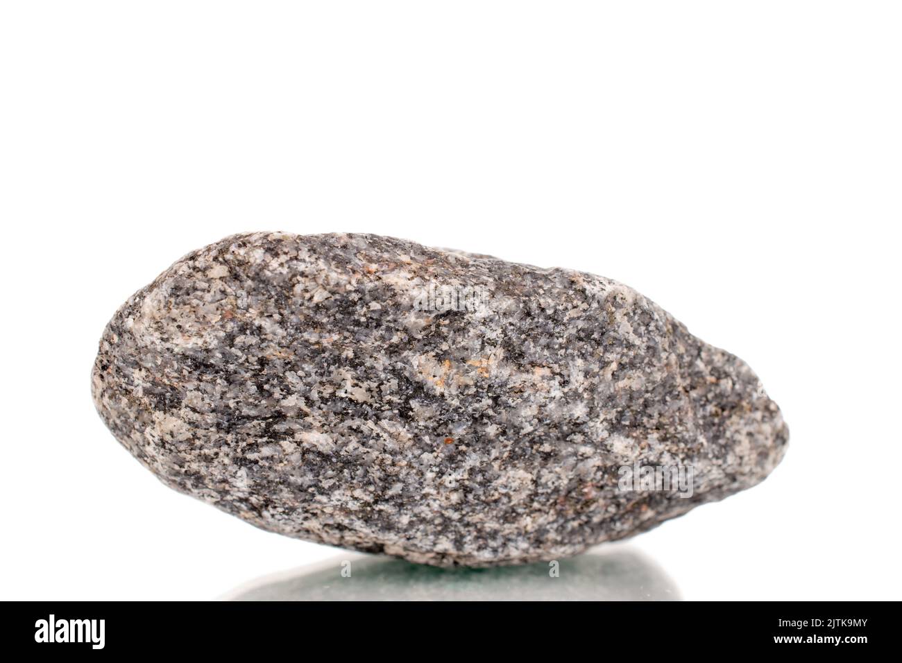 Una pietra di granito, primo piano, isolato su uno sfondo bianco. Foto Stock