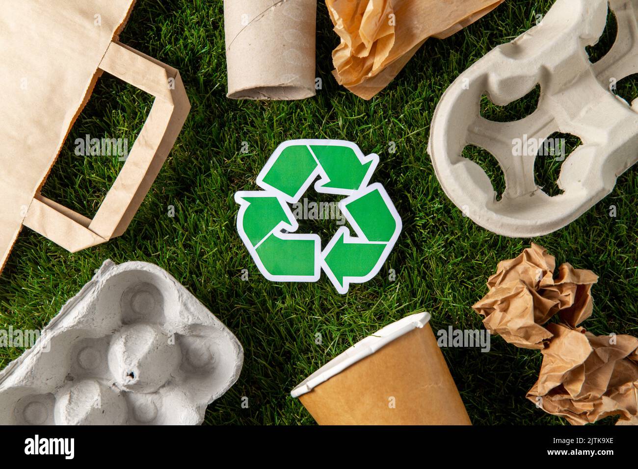 cartello verde di riciclaggio e rifiuti di carta sull'erba Foto Stock